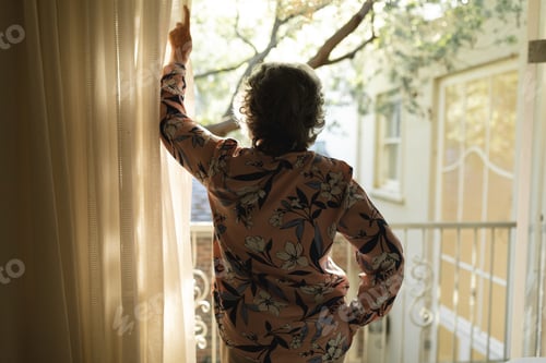 Preview: Senior caucasian woman standing on balcony and looking away