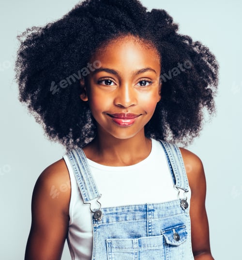 Preview: Young African girl smiling against a gray background