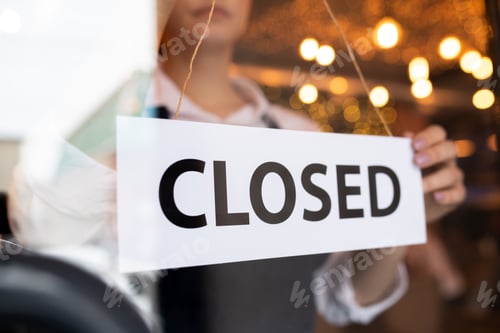 Preview: Paper with notice closed behind door of cafe on background of young waitress