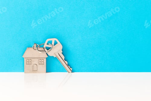 Preview: House Key and Keychain Against Blue Background