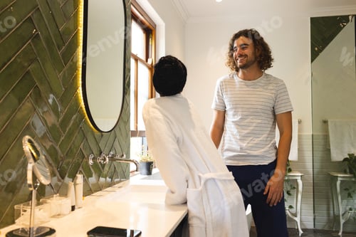 Preview: A young diverse couple enjoys a moment in a stylish bathroom, doing their morning skincare routine