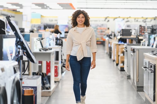 Preview: Woman walking through electronics store, choosing home appliances