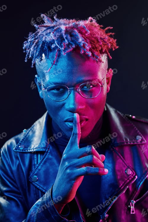 Preview: In glasses. Futuristic neon lighting. Young african american man in the studio