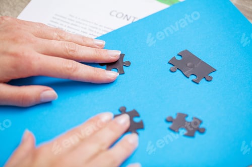 Preview: Business concept, woman's hands make up a puzzle symbolizing the success of the company
