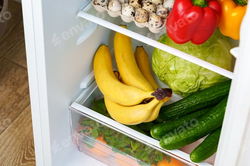 Preview: Open Refrigerator With Fresh Produce, Eggs, And A Blue Container