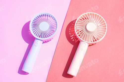 Preview: Small portable mini fans on pink background close-up.
