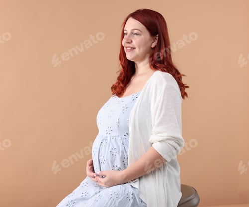 Preview: Beautiful pregnant woman in dress on beige background