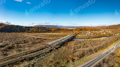 Preview: Long railroad bridge over river leading to valley settlement