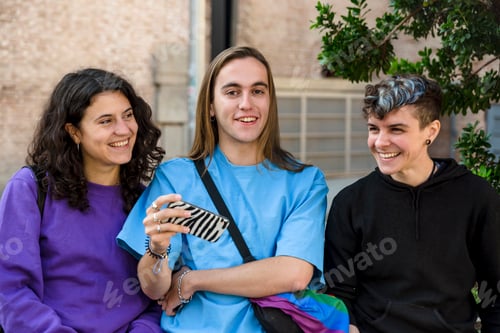 Preview: Young diverse friends taking selfie with a mobile phone outdoors.