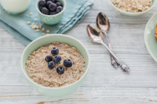 Preview: Oatmeal porridge bowl on the white wooden background.