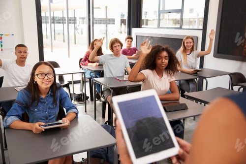 Preview: Teacher uses tablet in high school class, over shoulder view