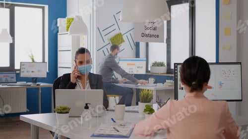 Preview: Freelancer worker with protection mask discussing on phone for new strategy