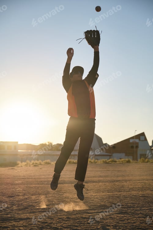 Preview: Baseball player jumping catching ball during sunrise game