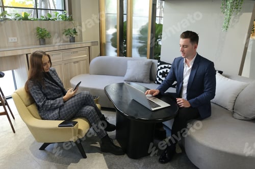 Preview: two attractive young people having a business meeting in a modern cafe.