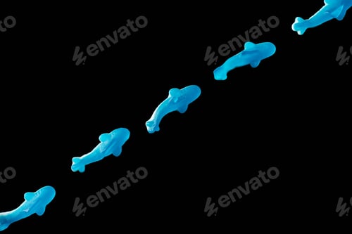 Preview: top view of diagonal of blue jelly candies in shape of dolphins isolated on black