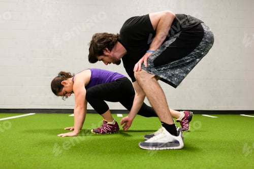 Preview: Personal trainer working with mid adult woman in gym