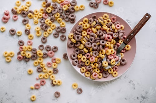Preview: Multi-colored corn rings on a pink plate for breakfast, healthy food.