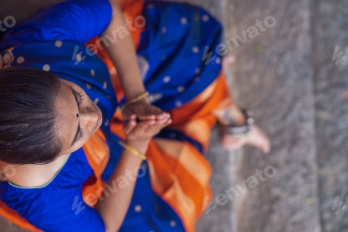 Preview: Overhead shot of a south Asian yogini in a sari doing asana in an ancient temple.