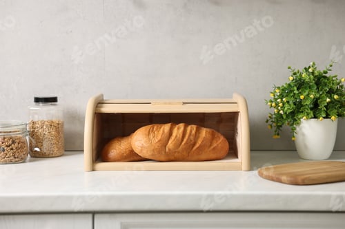 Preview: Wooden bread basket with freshly baked loaves on white marble table in kitchen