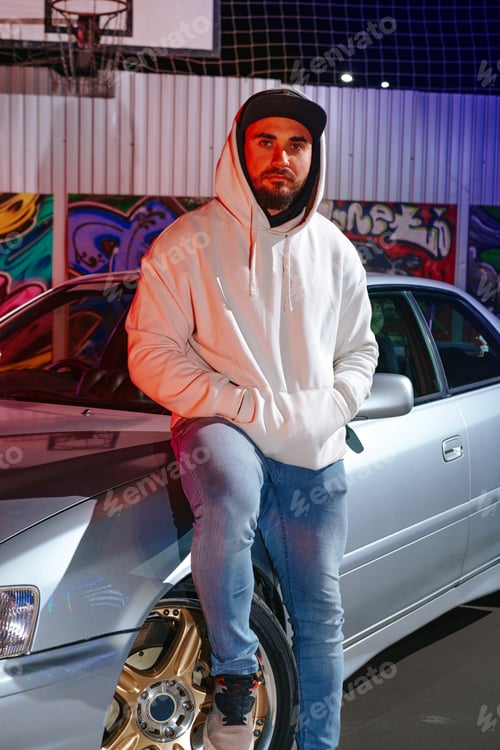 Preview: A young man standing next to his sport car at night parking