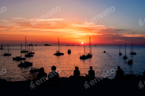 Preview: Young people admire a beautiful sunset over the horizon of the Mediterranean Sea.