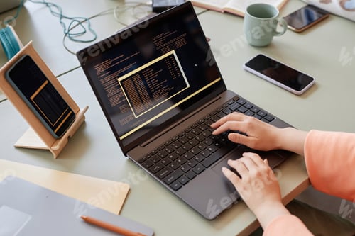 Preview: Close up of unrecognizable woman writing code on multiple devices