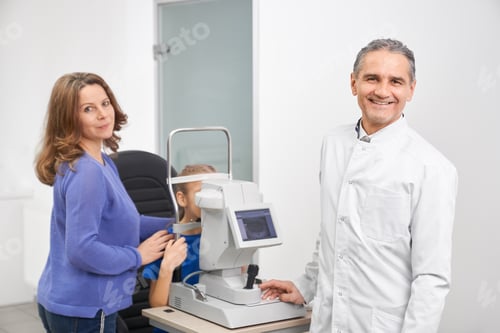 Preview: Male oculist and mother posing while checking sight of girl