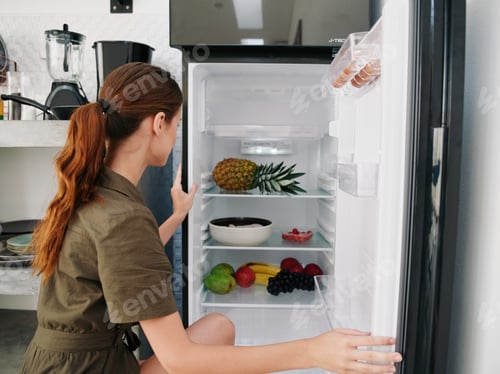 Preview: A woman opened the refrigerator and looks sadly into it, wondering what to cook, defrosted the