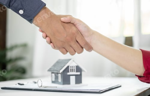 Preview: Businessmen and brokers real estate agents shake hand after completing negotiations to buy houses