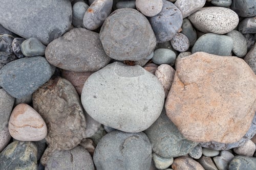 Preview: Large stones of different shapes on the riverbank close-up.
