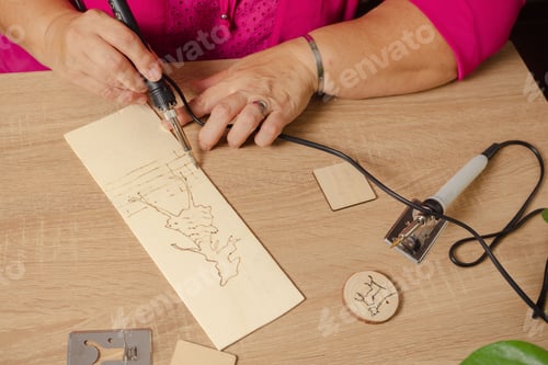 Preview: woman drawing with a pyrograph