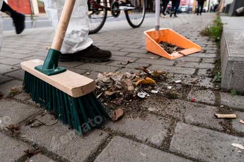 Preview: Closeup of a green street broom used in cleaning a cobblestone street