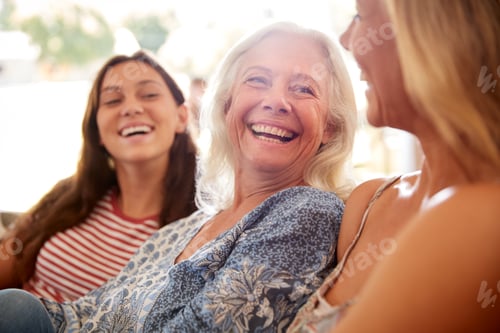 Preview: Mother With Adult Daughter And Teenage Granddaughter Relaxing On Sofa And Talking At Home