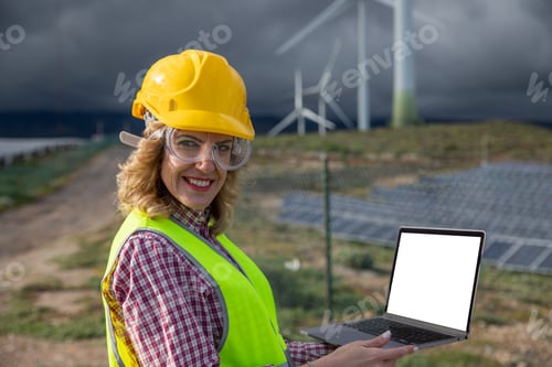 Preview: Female engineer use her laptop while working in solar power plant, screen with mockup