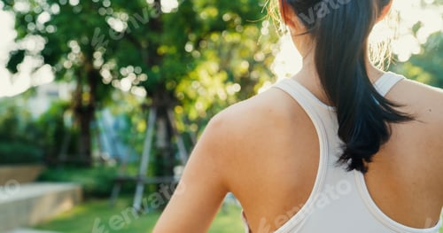 Preview: lady exercises stretching her body warm up after running in urban park environment.