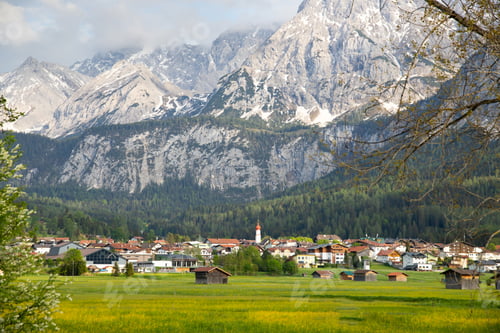 Preview: Beautilful green meadow and alpine village in spring, Austria