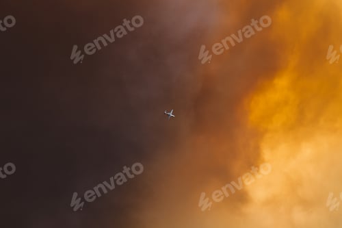 Preview: Low angle shot of an airplane in colorful clouds in California wildfire