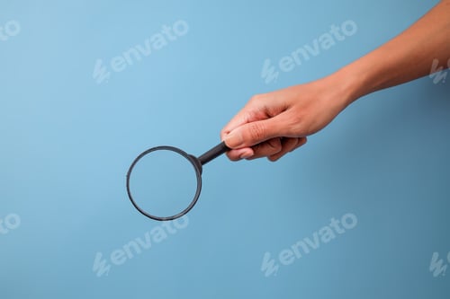 Preview: Hand Holding Magnifying Glass, Symbolizing Search, Analysis And Inspection On Blue Background