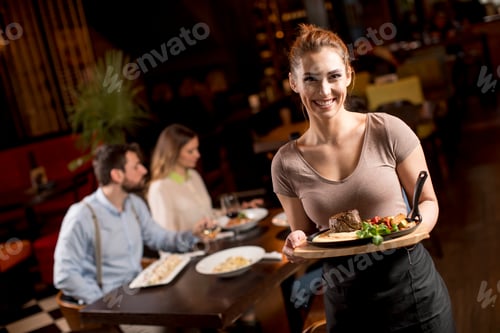 Preview: Waitress holding a wooden plate with beef steak in the restaurant