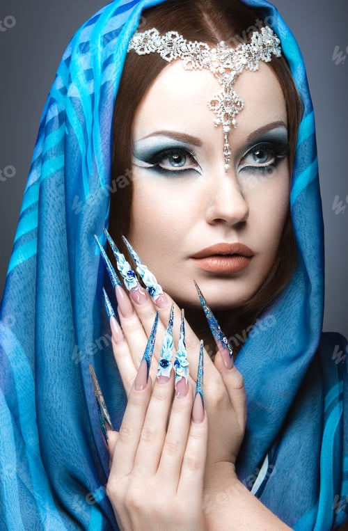 Preview: Beautiful girl in eastern Arabic image with long nails and bright blue make-up.