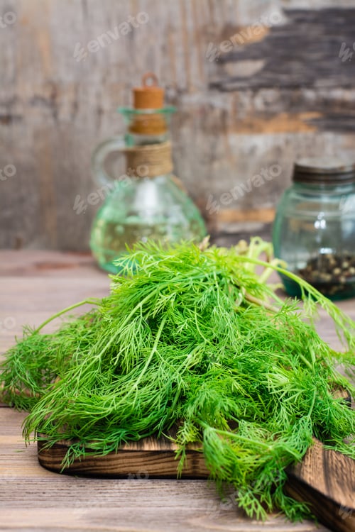 Vista previa: A bunch of fresh dill on a cutting board on a wooden table. Fragrant seasoning in rustic style