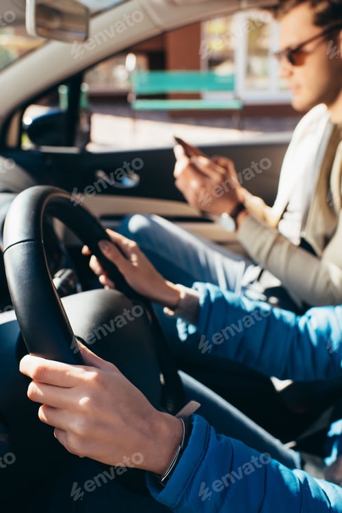 Preview: partial view of woman driving car with boyfriend near by, traveling concept
