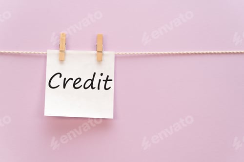 Preview: sticker with the inscription Credit hangs with a clothespin on a rope on a purple background