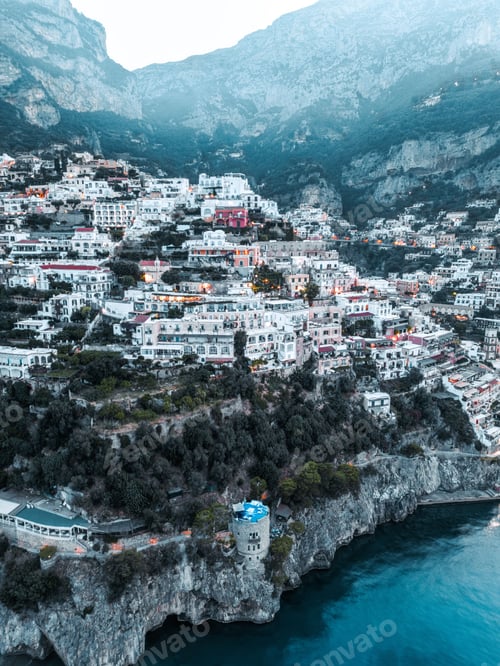 Preview: Vertical drone shot of the village and commune of Positano stretching over hills to a shore in Italy