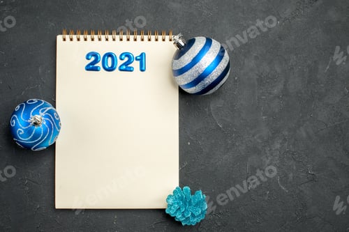 Visualização: vista superior: bloco de notas aberto com escrita e brinquedos de árvore no fundo escuro, cor da foto, natal, ano novo