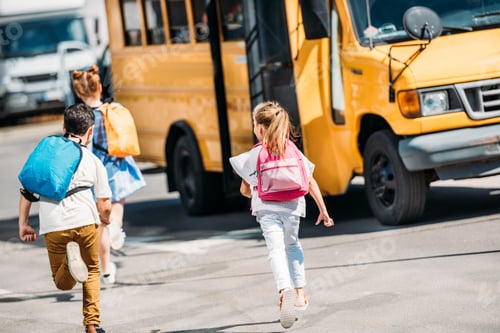 Preview: rear view of adorable schoolchildren running to school bus