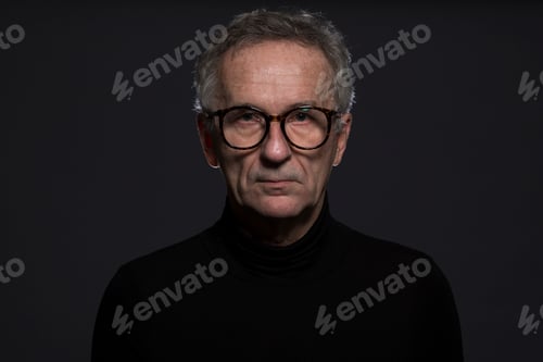 Preview: Portrait of serious senior man wearing glasses in front of dark background