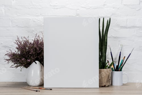 Preview: close up view of empty drawing easel and plants in flowerpots on table