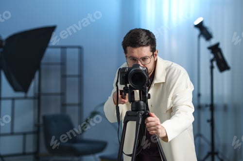 Preview: Man with professional video camera in studio