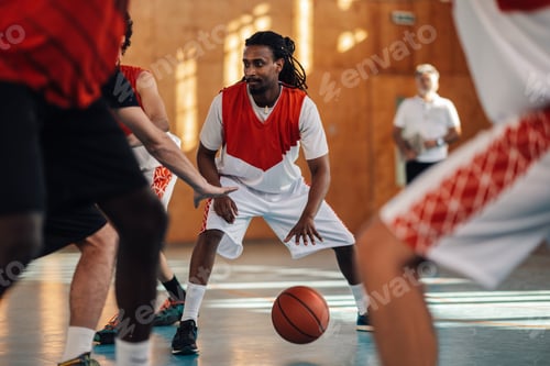 Preview: An interracial basketball player is dribbling a ball in crowd at training.